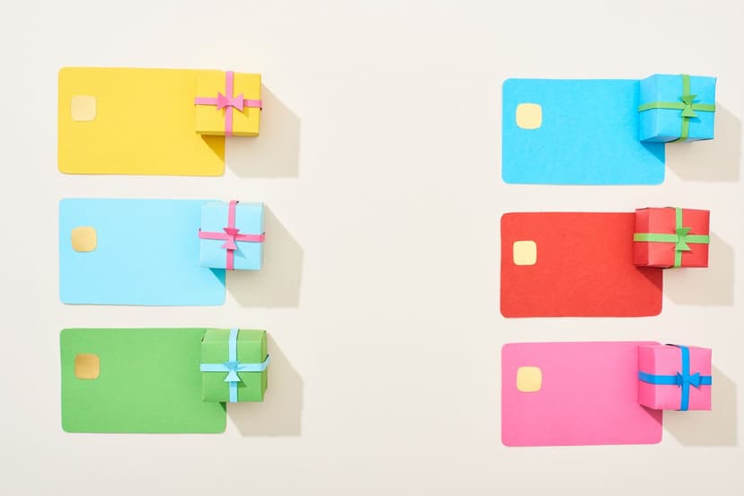 Six credit cards of different bright colors, with tiny gift boxes of similar colors on top of them